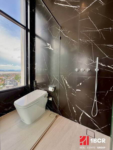 Ein Badezimmer in einer 4-Zimmer-Wohnung mit Marmorstangen und Blick auf die Stadt.