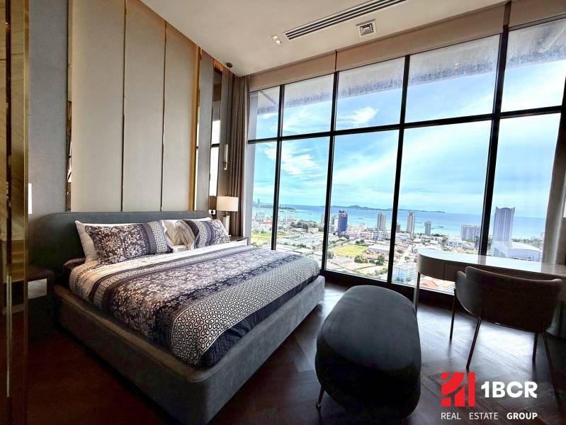 Schlafzimmer in einer 4-Zimmer-Wohnung mit großem Fenster bietet Blick auf die Stadt und die Küste.