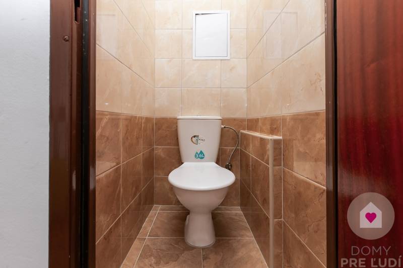 Toilette mit Keramikfliesen in einer Einzimmerwohnung.