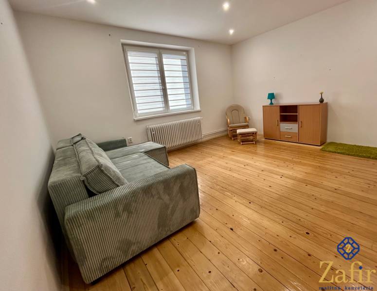 Helles Wohnzimmer in einer 3-Zimmer-Wohnung mit Holzboden, Sofa und Möbeln.