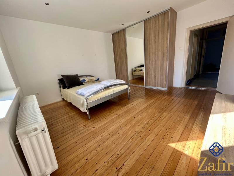 Schlafzimmer in einer 3-Zimmer-Wohnung mit Holzboden und Einbauschrank.