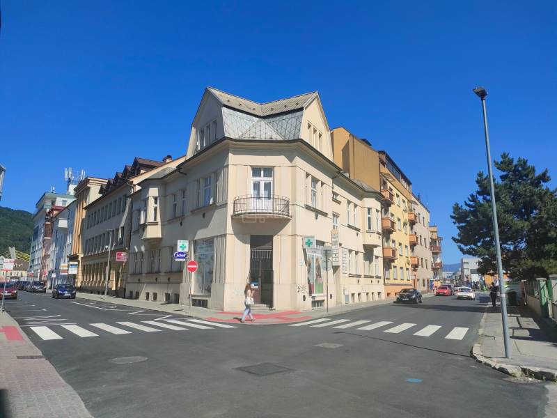 Kreuzung in der Milcova-Straße in Žilina mit Geschäftsräumen und umliegenden Gebäuden.