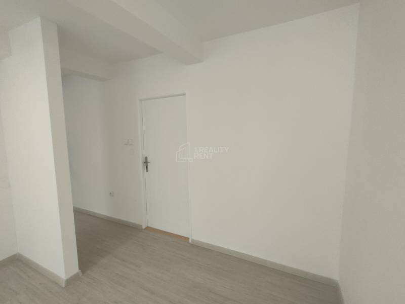 Weiße Wände und Türen in Geschäftsräumen mit Holzboden.