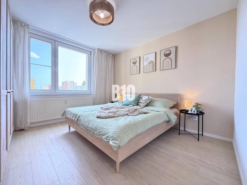 Ein Schlafzimmer in einer 3-Zimmer-Wohnung mit moderner Einrichtung und großem Fenster.