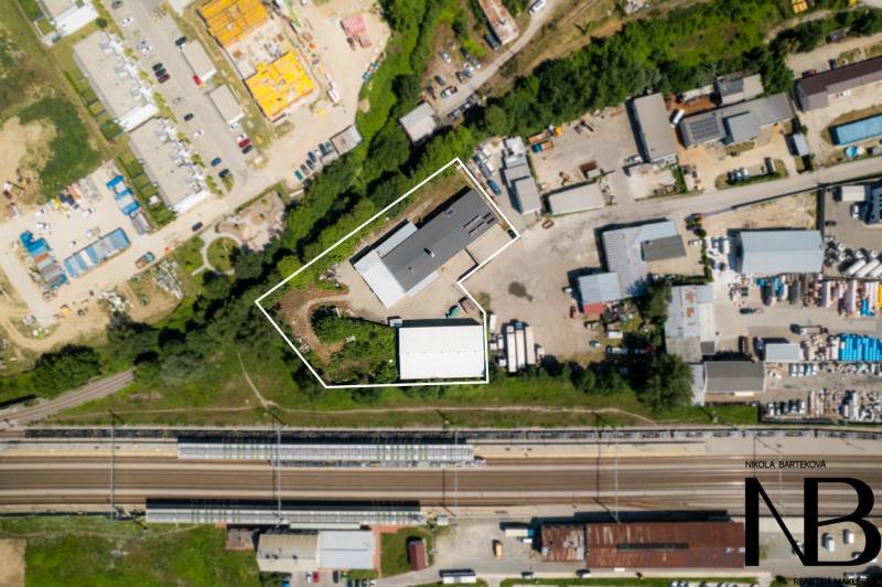 Luftaufnahme von Lagerhäusern und Hallen in Trenčín in der Kasárenská-Straße bei der Eisenbahnstrecke.