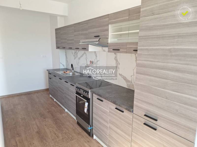 Küche in einer 2-Zimmer-Wohnung mit Holzboden und grauen Schränken.