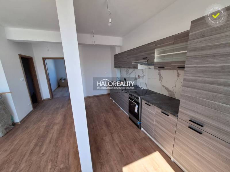 Die Küche einer 2-Zimmer-Wohnung mit Holzböden und grauen Schränken.