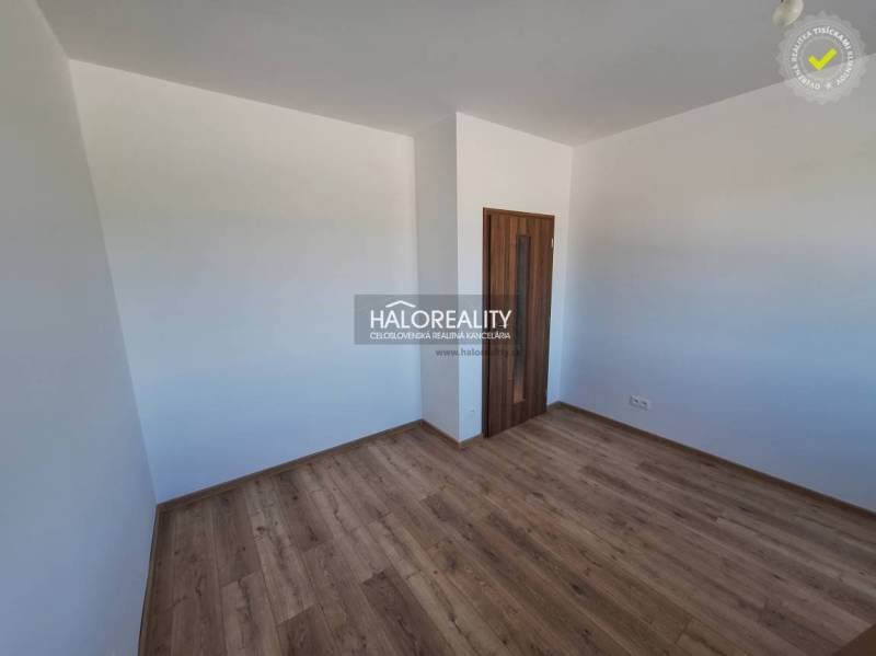 Ein Zimmer mit Holzboden und weißen Wänden, Teil einer 2-Zimmer-Wohnung.