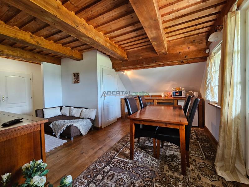 Holzdecke und Tisch im Esszimmer des Einfamilienhauses mit Sofa und Dekorationen.