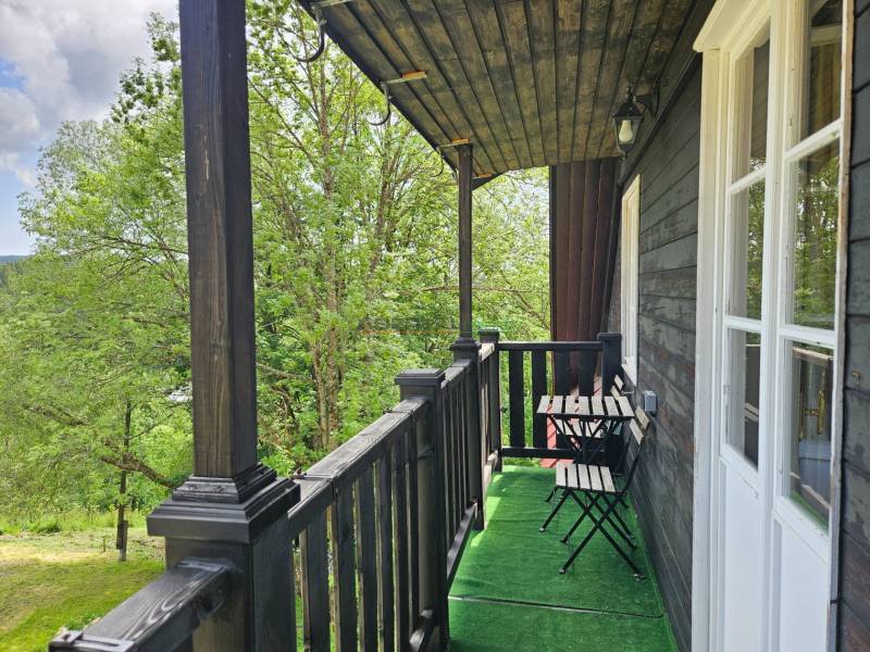 Der Balkon eines Einfamilienhauses mit einem Holzgeländer und Blick auf die Natur in Donovaly.