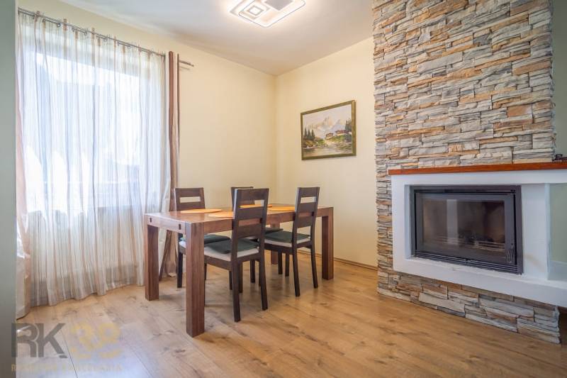 Esszimmer in der Ferienwohnung mit Holztisch und Kamin mit Steinverkleidung.
