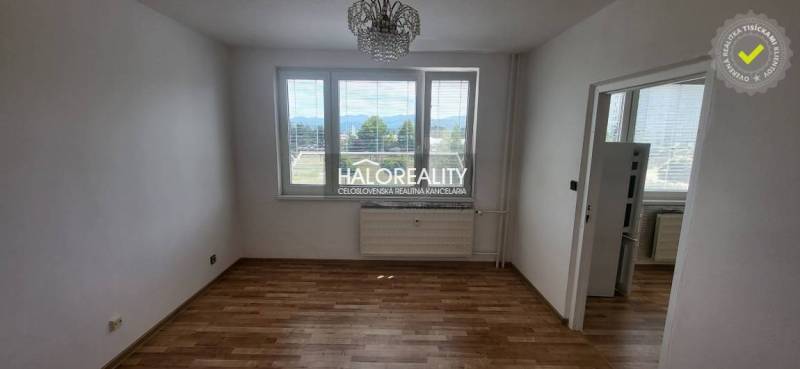 Ein Zimmer in einer Einzimmerwohnung mit Holzboden und Blick aus dem Fenster.