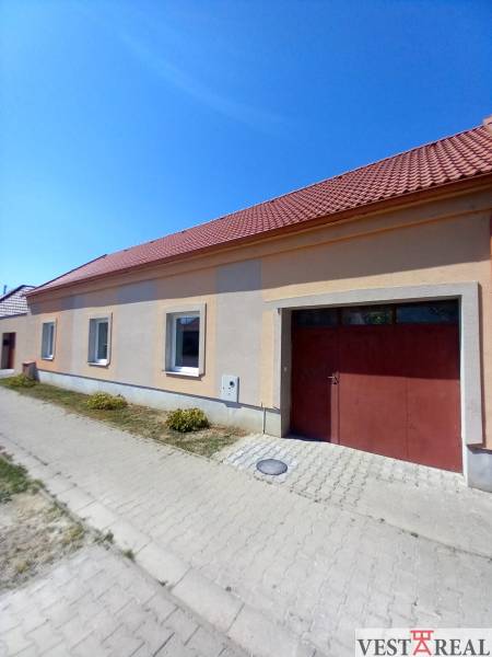 Ein Einfamilienhaus in Trakovice mit einem Schrägdach und zwei Fenstern, die zur Straße zeigen.
