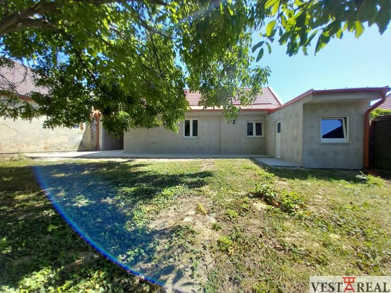 Ein Einfamilienhaus in Trakovice mit Garten, umgeben von Bäumen und grünem Gras.