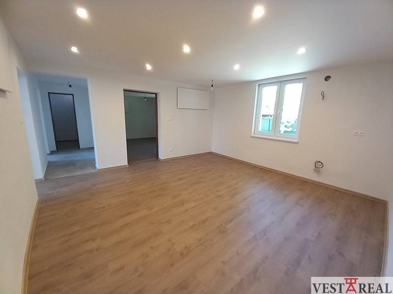 Wohnzimmer in einem Einfamilienhaus mit Holzboden und weißen Wänden.