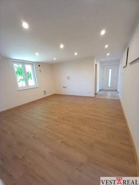 Ein geräumiges Zimmer mit Laminatboden und Spotlichtern in einem Einfamilienhaus.