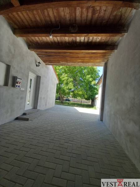 Der Durchgang zwischen den Gebäuden des Einfamilienhauses in Trakovice, der gepflasterte Bereich führt zum Hof.