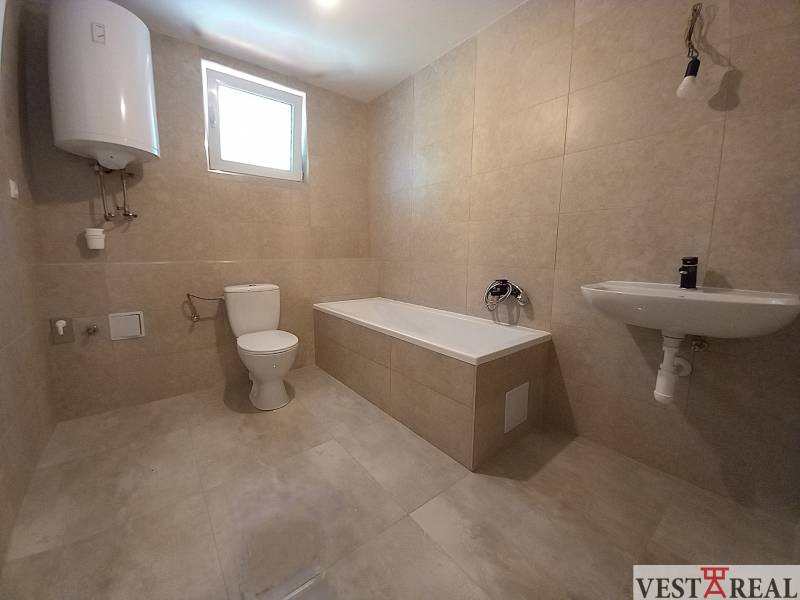 Badezimmer im Einfamilienhaus mit Badewanne, Waschbecken und WC.
