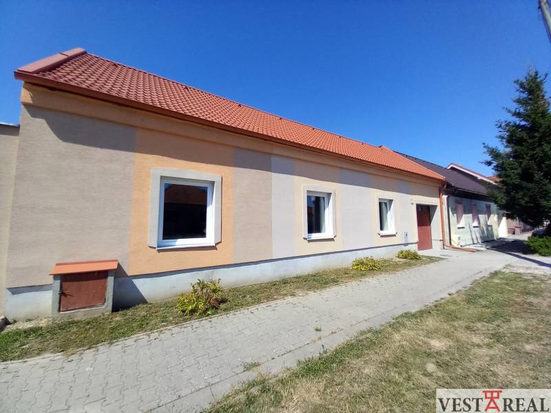 Ein Einfamilienhaus in Trakovice mit einer orangefarbenen Fassade und einem roten Dach.