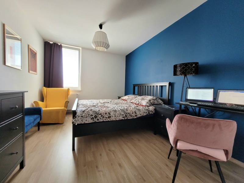 Schlafzimmer in einer 3-Zimmer-Wohnung mit bunten Sesseln und einer Arbeitsecke.