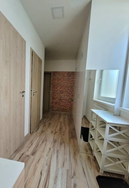 Ein heller Flur mit Holztüren und Ziegeldekor in einer 3-Zimmer-Wohnung.