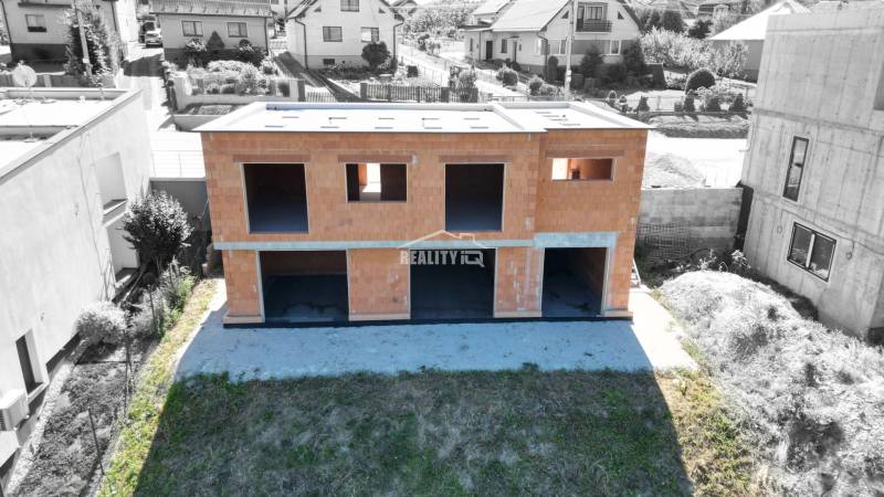 Unvollendetes Einfamilienhaus in Trnová Žilina, umgeben von weiteren Häusern und Grünflächen.