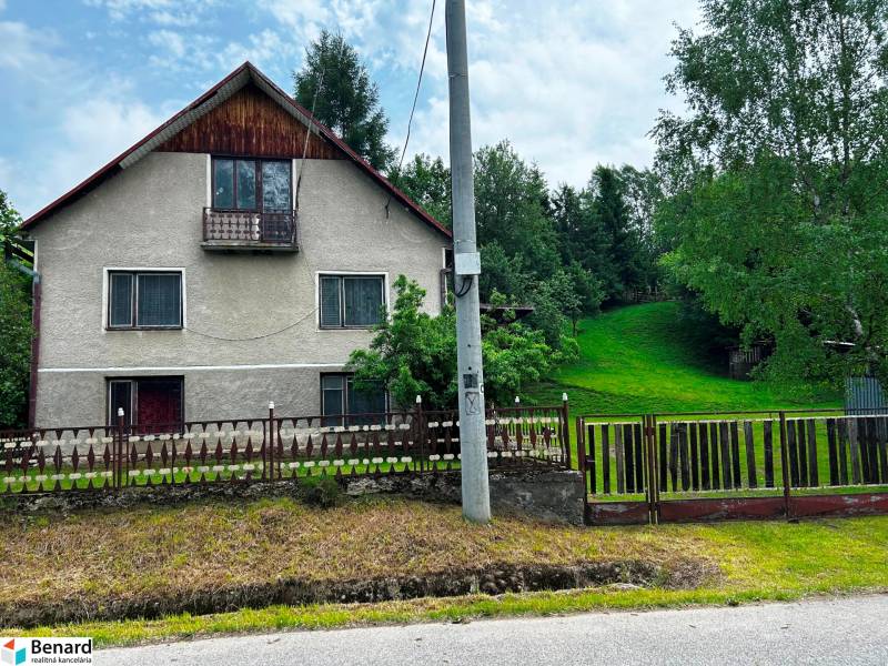 Ein Einfamilienhaus in Veľká Lesná mit gepflegtem Garten und Rasen, umgeben von Bäumen.