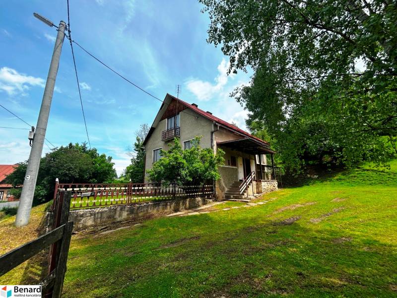 Ein Einfamilienhaus in Veľká Lesná mit einem weitläufigen Hof und Baumbewuchs.