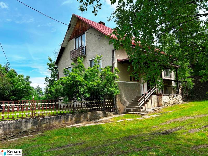 Ein Einfamilienhaus in Veľká Lesná, umgeben von Grün und einem Holzzaun.