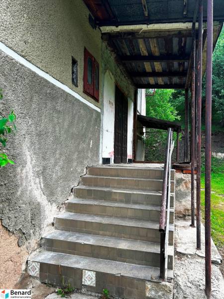 Der Eingang mit Treppe zu einem Einfamilienhaus in Veľká Lesná, umgeben von grüner Vegetation.
