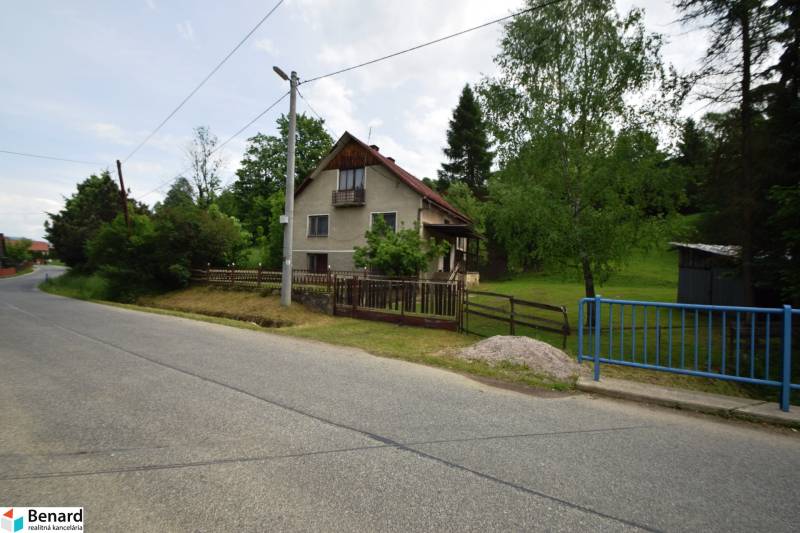 Ein Einfamilienhaus in Veľká Lesná an der Straße, umgeben von Grün und einem Zaun.