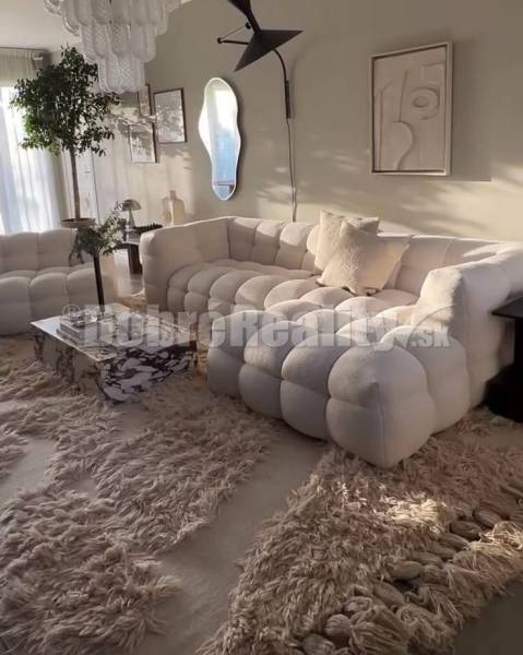 Ein stilvolles Wohnzimmer in einer 3-Zimmer-Wohnung mit einem bequemen Sofa und Teppich.