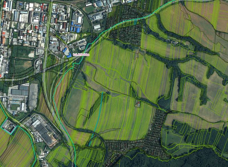 Luftaufnahme von landwirtschaftlichen und forstwirtschaftlichen Flächen im Bezirk Prievidza mit angrenzenden Gebäuden.