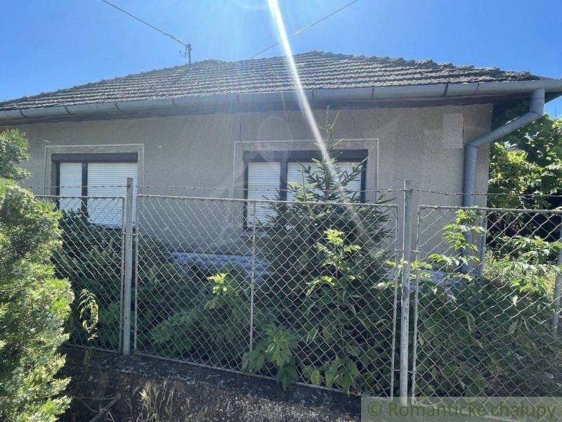 Ein Einfamilienhaus in Nové Zámky, vor dem sich ein Metallzaun und ein Garten mit Sträuchern befindet.