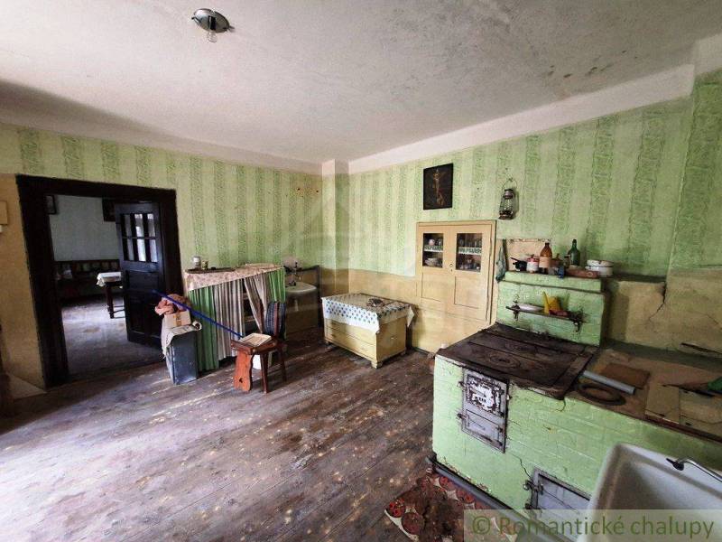 Eine Küche in einem Einfamilienhaus mit antiken Möbeln und einem Herd, sichtbarer Holzboden.