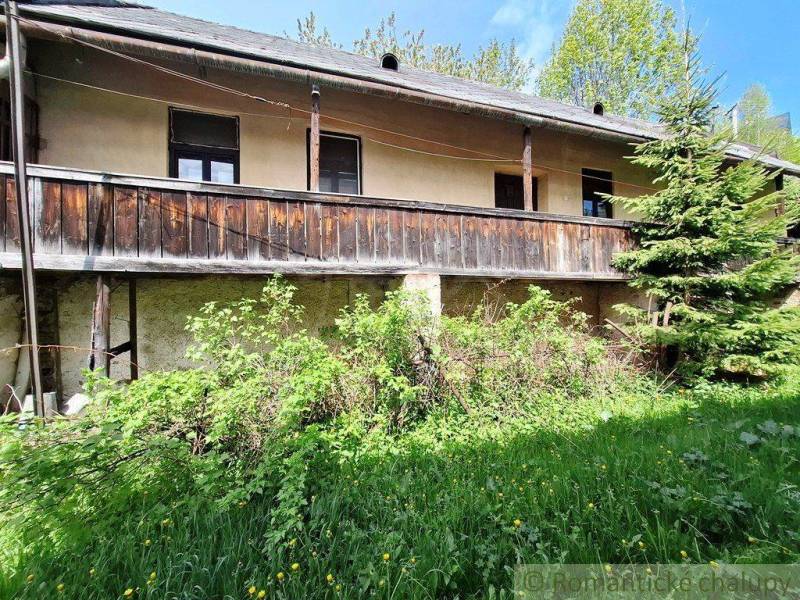 Ein Einfamilienhaus in Pohorelá mit einem älteren Holzbalkon und gepflegtem Grün.