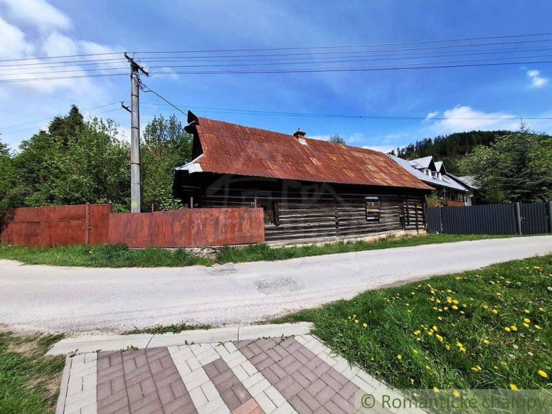 Ein Einfamilienhaus in Pohorelá mit Holzkonstruktion, neben der Straße und Grünflächen.