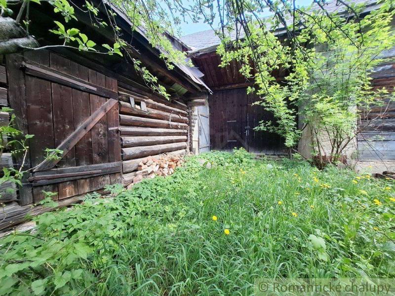 Holzbauten und ein überwucherter Garten bei einem Einfamilienhaus in Pohorelá.