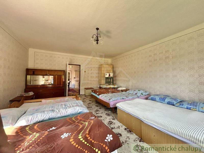 Ein Schlafzimmer in einem Einfamilienhaus mit fünf Betten, einem Schrank und einer dekorativen Tapete.