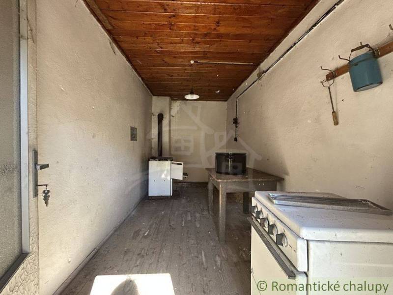 Eine Küche in einem Einfamilienhaus mit einer Holzträgerdecke und einer Wandgarderobe.