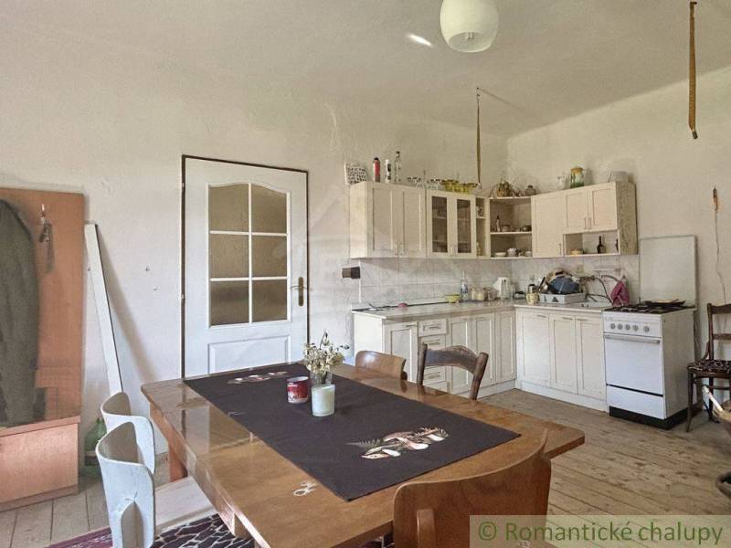 Eine Küche in einem Einfamilienhaus mit einem Holztisch und weißen Möbeln.