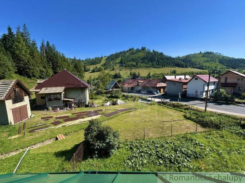Ein Einfamilienhaus in Spišská Nová Ves, umgeben von grünen Hügeln und einer Wiesenfläche.