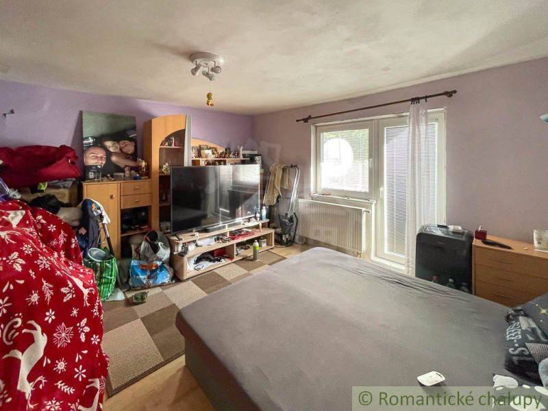 Wohnzimmer in einem Einfamilienhaus mit Sofa, Fernseher und Wanddekorationen.