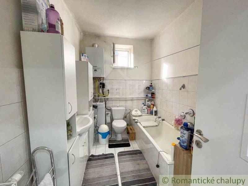 Badezimmer in einem Einfamilienhaus mit Sanitäranlagen, Schränken und Badewanne.
