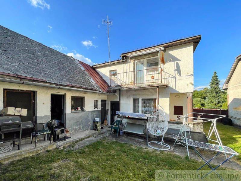 Ein Einfamilienhaus in Sielnica, ein Garten mit Terrasse, ein Wäschetrockner, ein Schaukelstuhl, blauer Himmel.