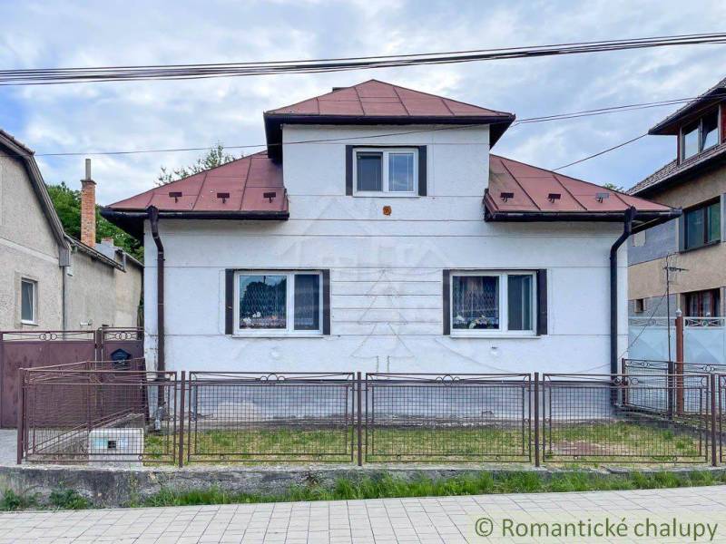 Ein Einfamilienhaus in Sielnica mit einem Blechdach und einem Metallzaun.