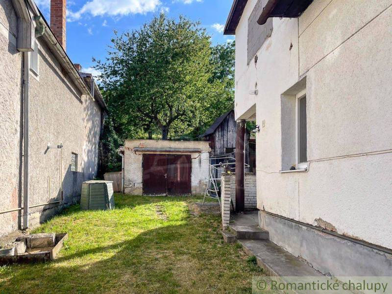 Hof eines Einfamilienhauses in Sielnica mit Unterstand und Baum im Hintergrund.