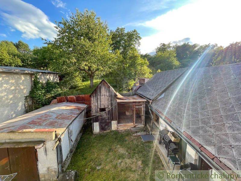 Der Hof eines Einfamilienhauses in Sielnica mit Garten und Holznebengebäude.