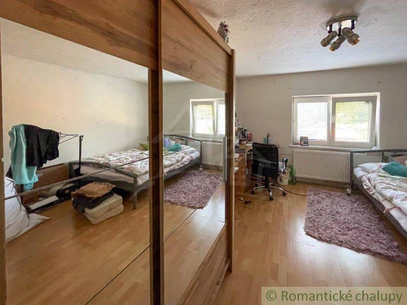 Helles Zimmer mit Schlaf- und Arbeitsbereich in einem Einfamilienhaus.