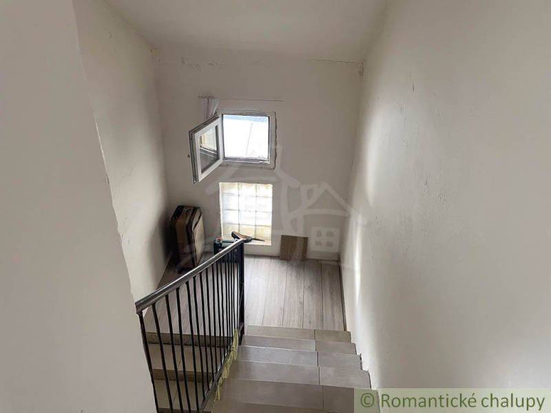 Treppe in einem Einfamilienhaus mit verglastem Fenster und matten Wänden.